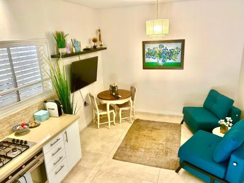 a kitchen and living room with a table and chairs at לארח, זה בטבע שלנו in Kefar Blum