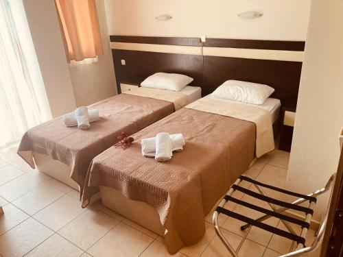 two beds in a hotel room with towels on them at VILLA HARIKLIA in Paralia Katerinis