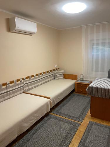 1 dormitorio con 2 camas, escritorio y ventana en Kertes nyaralóház, en Keszthely