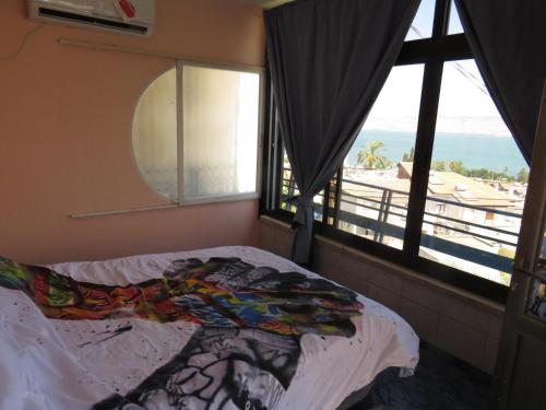 um quarto com uma cama e vista para a praia em cohen sea of galilee em Tiberias