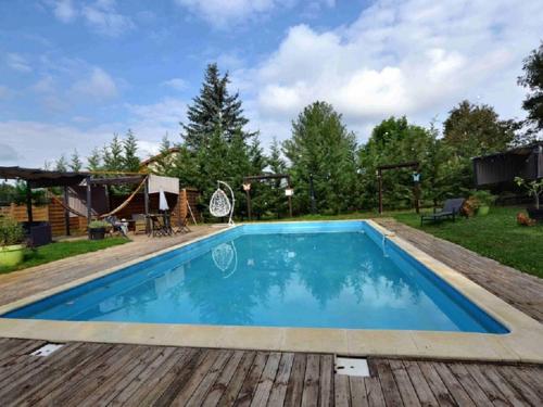 een zwembad met een houten terras en een achtertuin bij L'amarre aux anges in Cormatin