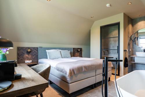 a bedroom with a large bed and a bathroom at Prins Hendrik Texel in Oost