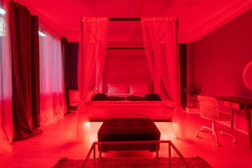 a red bedroom with a bed with a canopy at Joan Apartments & Spa in Skopje