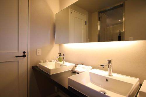 a bathroom with two sinks and a mirror at Hotel Regina Kawaguchiko in Fujikawaguchiko