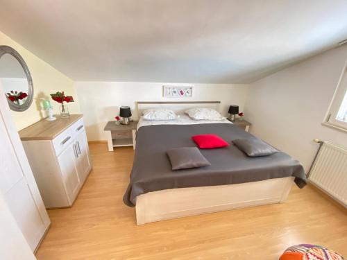 um quarto com uma cama grande e uma almofada vermelha em Apartments Tomi & Ivana em Trogir