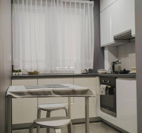 a kitchen with a table and two stools in it at Słoneczny pokój z balkonem. in Gdańsk