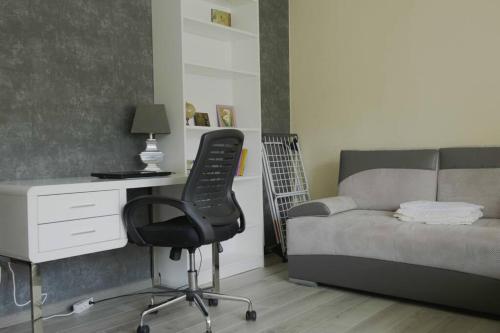 Słoneczny pokój z balkonem. في غدانسك: غرفة نوم مع مكتب وكرسي بجوار سرير