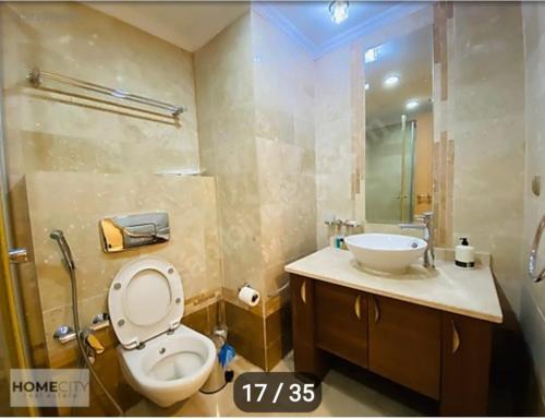 y baño con aseo y lavamanos. en Alanya gold city hotel main building 3 bedroom apartment, en Alanya