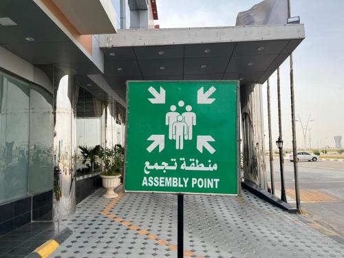 a sign for a assembly point in front of a building at فندق اليمامه الفندقية in Al Nairyah