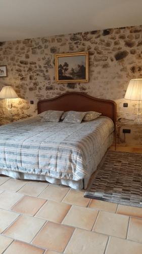 a bedroom with a bed in a stone wall at La Tour d'Enguernes in Montmeyan