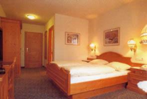 a bedroom with a bed and a desk with two lamps at Brauerei Gasthof Kraus in Hirschaid