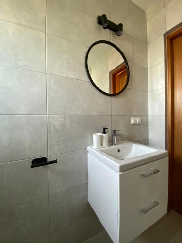 a bathroom with a white sink and a mirror at Stanica Przygody in Sztutowo