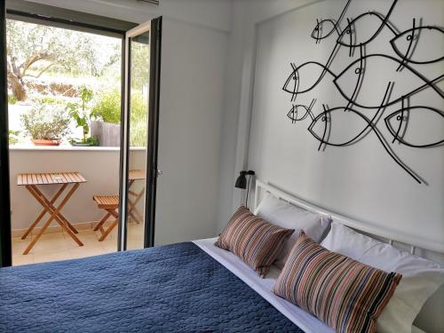 a bedroom with a blue bed with a wall art at EmMi Houses in Nafplio