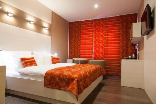 una camera da letto con un grande letto con accenti arancioni di Penzion Na Valech Hodonín a Hodonín