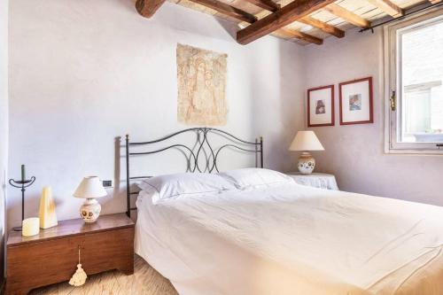 1 dormitorio con 1 cama blanca grande y 2 lámparas en Charming Castle, en Monte lʼAgello