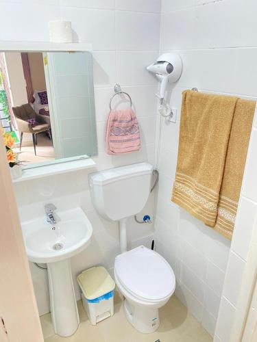 ein Badezimmer mit Toilette, Waschbecken und Spiegel in der Unterkunft Quarto Nº6 MARIA BONITA- Central Praia in Praia