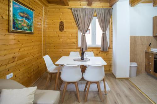 uma sala de jantar com uma mesa e cadeiras brancas em Fenix em Žabljak