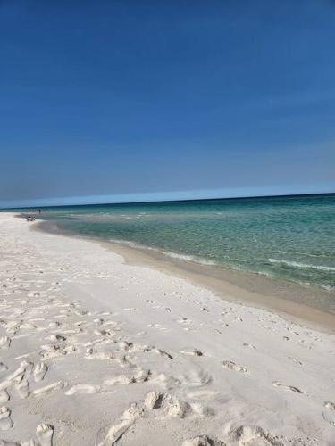 a sandy beach with the ocean in the background at Quiet 2 bedroom condo on Gulf with pool and pond in Pensacola Beach