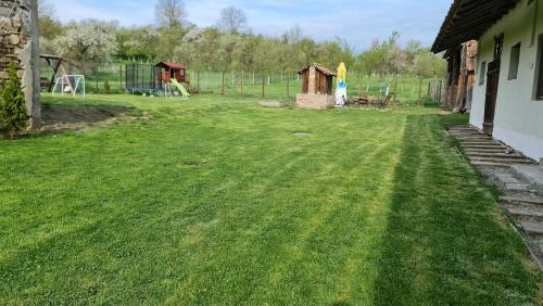 a yard with a fence and a playground at Casa pe Valea Hartibaciului(Bărcuț) in Bărcuţ