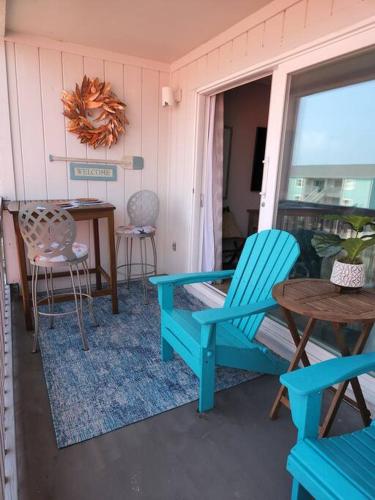 a porch with chairs and a table and a table and chairs at Quiet 2 bedroom condo on Gulf with pool and pond in Pensacola Beach