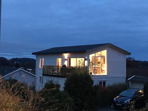 een wit huis met een balkon erop bij Topp moderne suite. in Larvik