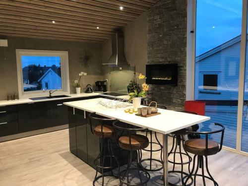 a kitchen with a large white island with stools at Topp moderne suite. in Larvik