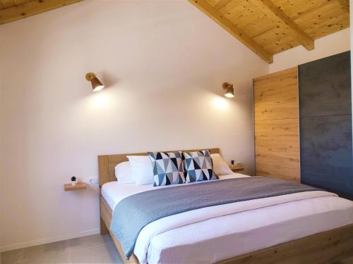 a bedroom with a bed with two lights on the wall at Stone house in vineyard in Račišće