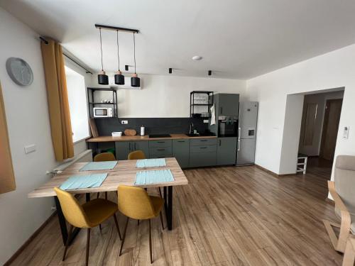 a kitchen and dining room with a wooden table and chairs at Elegantný Byt v Srdci Mesta in Trenčín