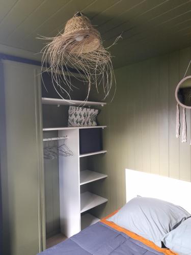 a bedroom with a shelf with a nest on the ceiling at Volcan Nature in Saint-Pierre-le-Chastel