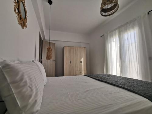 a bedroom with a white bed and a window at Mantalena's house in Antiparos