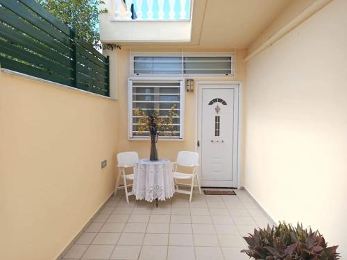 a patio with a table and chairs and a door at Takis house in Rafina