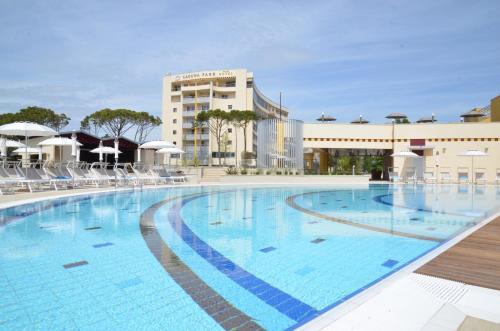 a large swimming pool with chairs and a building at Laguna Park Hotel 4Superior in Bibione