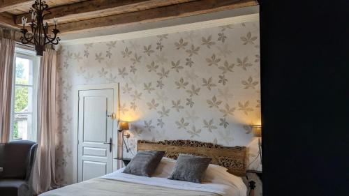 a bedroom with a bed and a wall with flowers at Manoir La Cerise in Fougerolles