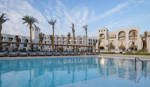 uma grande piscina em frente a um edifício em Serry Beach Resort em Hurghada