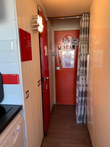 un couloir avec une porte rouge et un mur rouge dans l'établissement Arc1800 - T2 rénové - 4 pers - Les Villards - Rés Grand Arbois, à Arc 1800