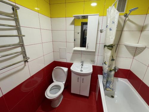 a bathroom with a toilet and a sink and a bath tub at Studio apartment on Vatutina in Vinnytsya