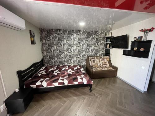 a bedroom with a bed and a chair in a room at Studio apartment on Vatutina in Vinnytsya