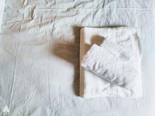 a white towel sitting on top of a bed at stone house / Evdilos Icaria (-50%) in Akamatra