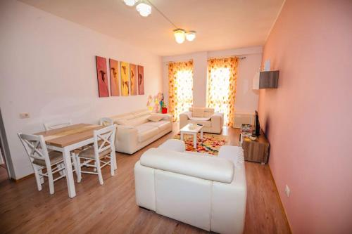 a living room with a white couch and a table at Happy stories' apartment in city centre in Shkodër