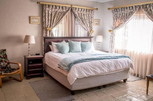 1 dormitorio con 1 cama grande y 2 ventanas en Entire Self catering Home in Springs, en Springs