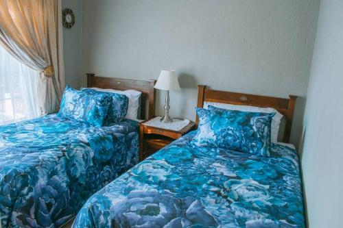 a bedroom with two beds and a lamp on a table at Entire Self catering Home in Springs in Springs
