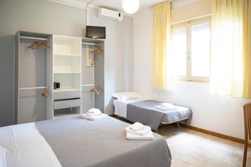 um quarto com duas camas e uma janela em Hotel Helvetia em Milano Marittima