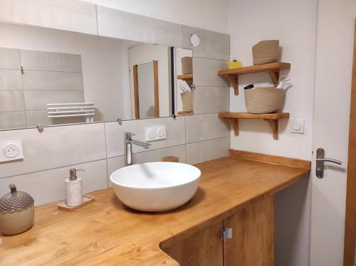 布里昂松Appartement vue montagne, cosy et chaleureux的木制柜台上带白色碗水槽的浴室
