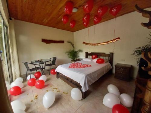 a bedroom with a bed with red and white balloons at Hostal Hilltop Salento in Salento