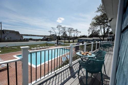 a balcony with a table and a view of a pool at Ocean View Terrace in Hampton Bays
