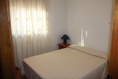 a bedroom with a white bed and a window at Casa Rural El Escondite in Ronda