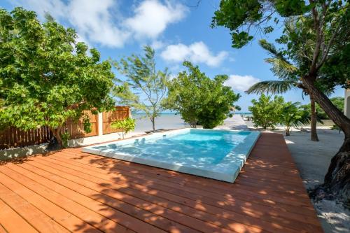 a swimming pool on a wooden deck next to the beach at Cottage 5 at Island Pearl Gold Standard Certified in Caye Caulker
