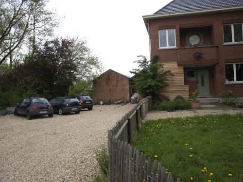 ein Haus mit Autos, die vor einer Einfahrt geparkt sind in der Unterkunft B&B Halen in Halen