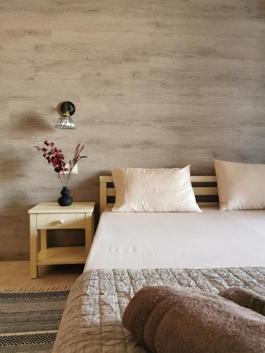 a bedroom with a bed and a table with a vase of flowers at Armonia Petra House in Kavála