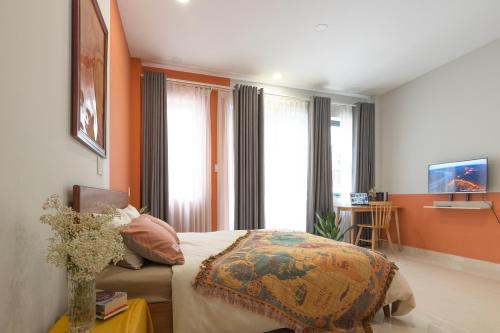 Schlafzimmer mit einem Bett mit orangefarbenen Wänden und Fenstern in der Unterkunft Karat Home in Ho-Chi-Minh-Stadt